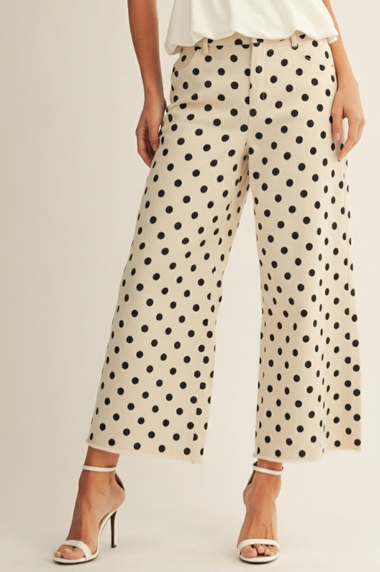 Woman wearing polka dot pants on a plain background