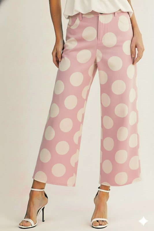 Pink polka dot pants worn by a person on a plain background