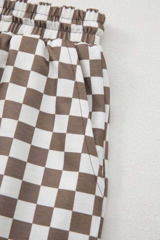 Brown and white checkered pants on a light gray background