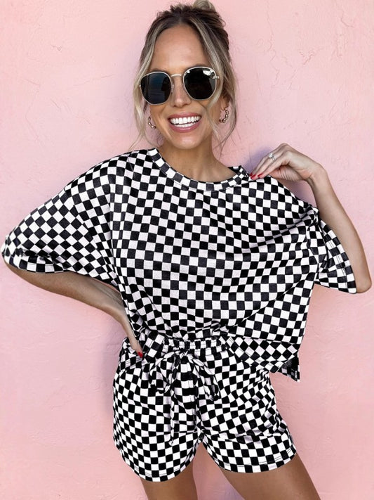 Woman wearing a black and white checkered outfit against a pink background