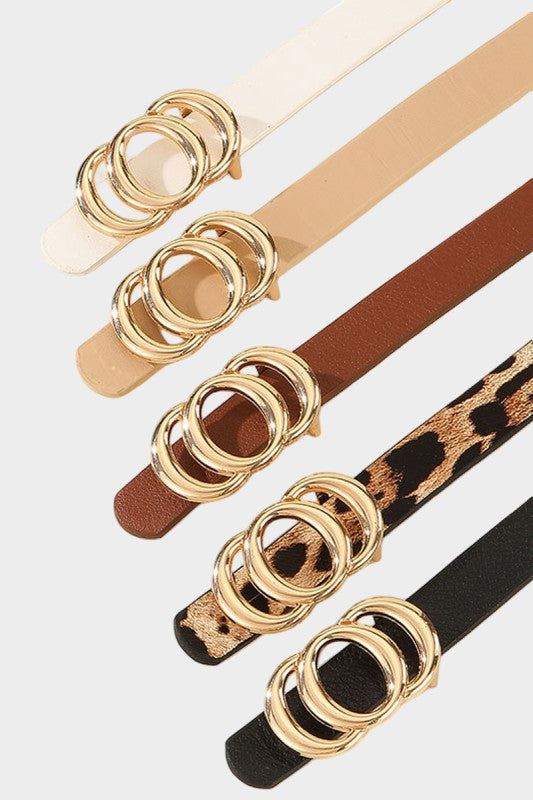 Set of belts with gold ring detailing in various colors on a white background