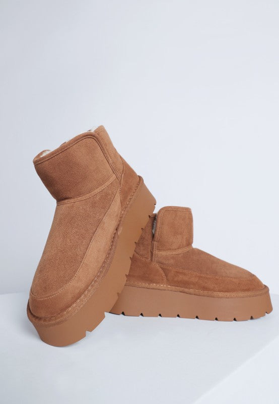 Pair of brown suede platform boots on a white background