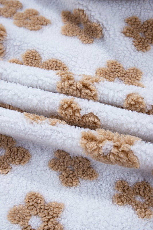 Close-up of a textured fabric with beige floral patterns on a white background