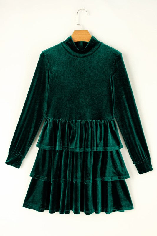 Green velvet dress on a hanger against a white background