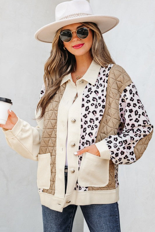 Woman wearing a leopard print and beige quilted jacket against a white background