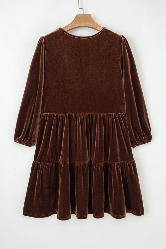 Brown velvet dress on a hanger against a white background