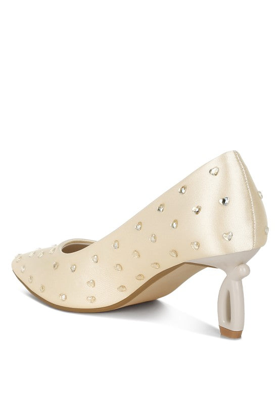 Beige high-heeled shoes with pearl embellishments on a white background
