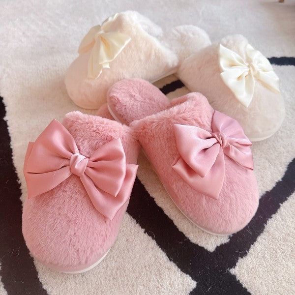 Pink slippers with large bows on a patterned surface