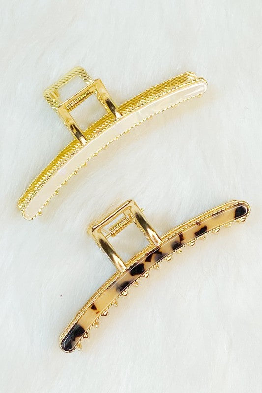 Two gold hair clips on a white background