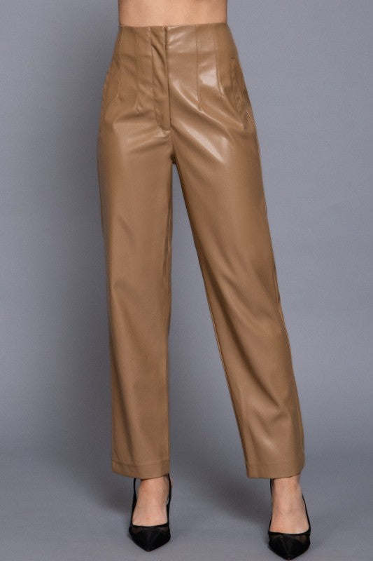 Brown leather pants worn by a person on a gray background