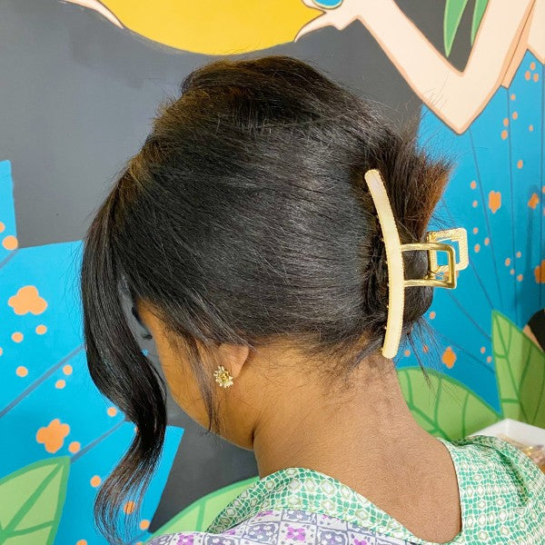 Person with a hair clip in their hair against a colorful background