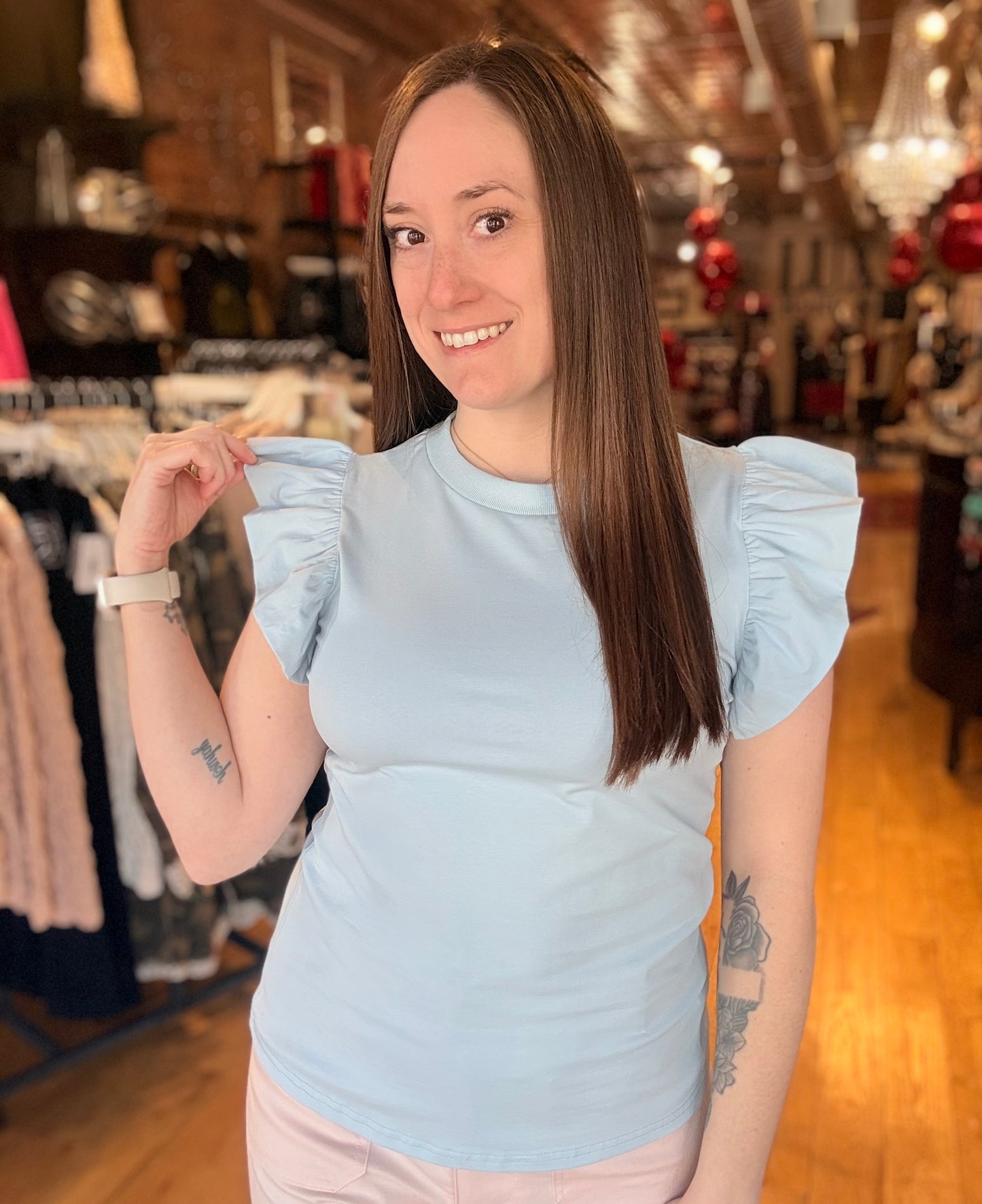 Woman wearing a light blue top in a clothing store