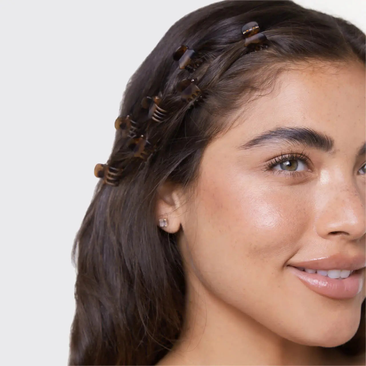 Woman with hair extensions styled in her hair on a plain background