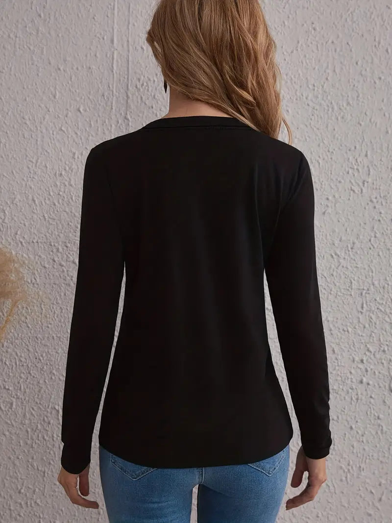 A woman wearing a black long sleeve t-shirt and blue denim jeans.