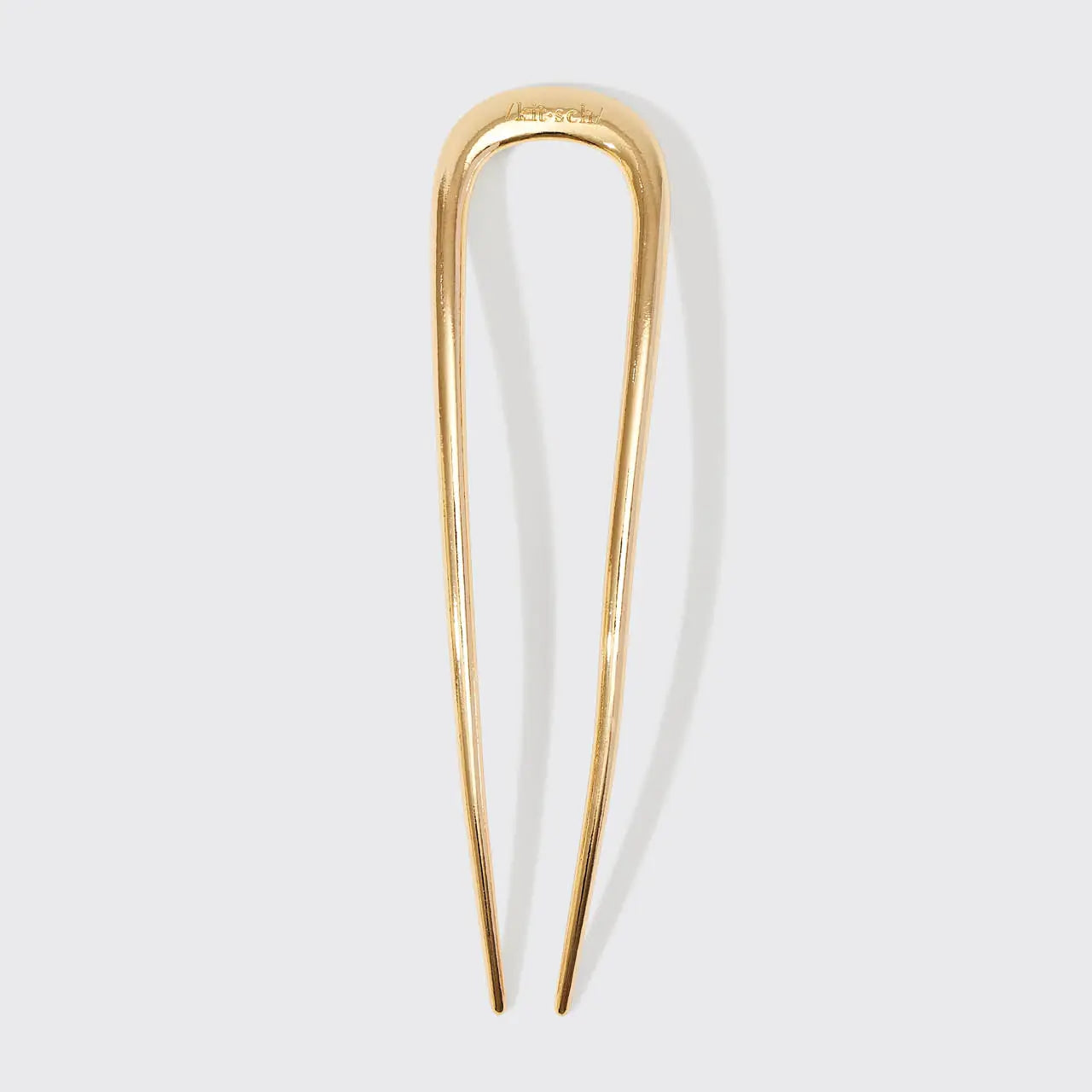 Gold hairpin on a light gray background