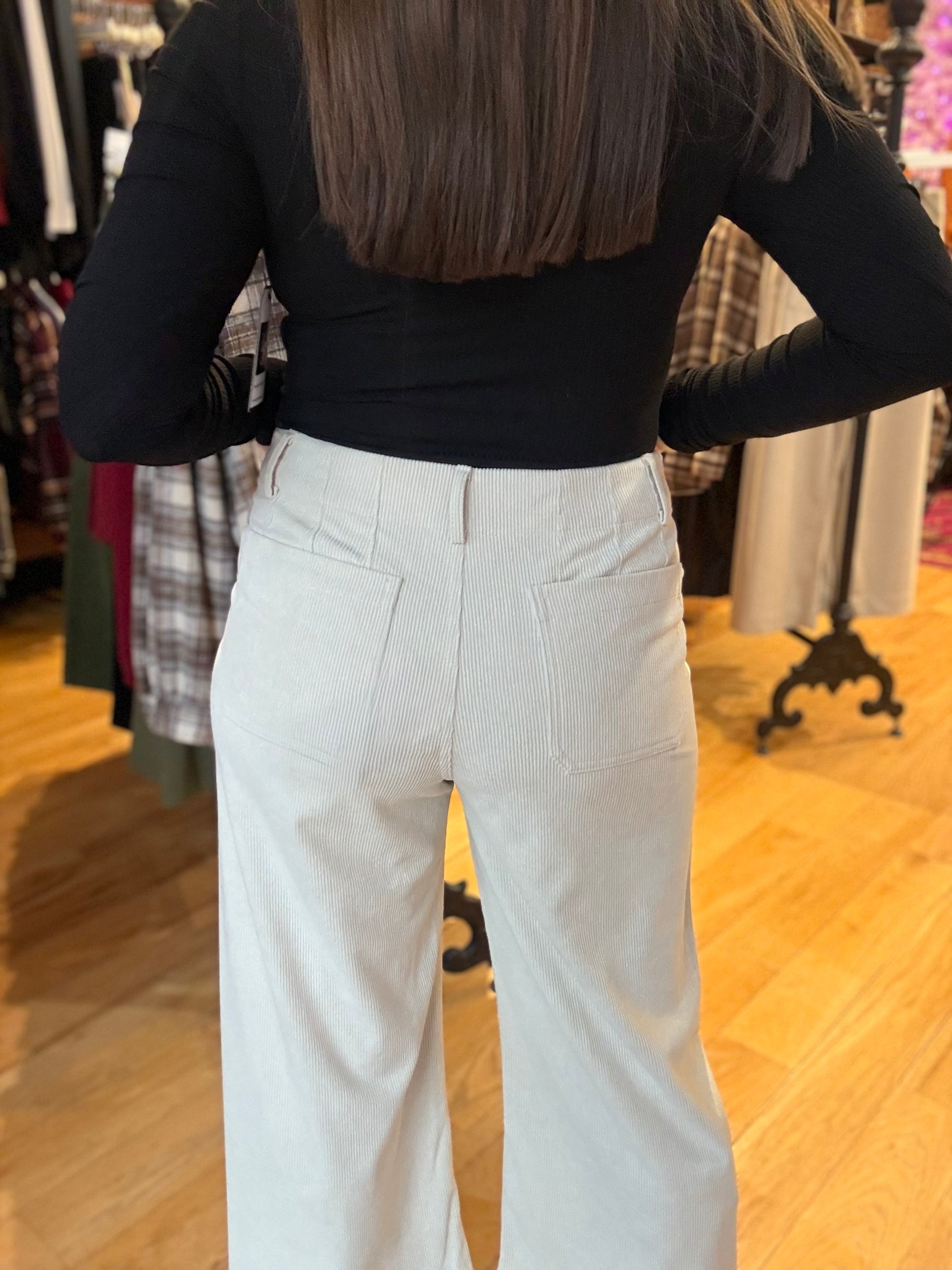 Person wearing a black top and light blue pants in a store setting
