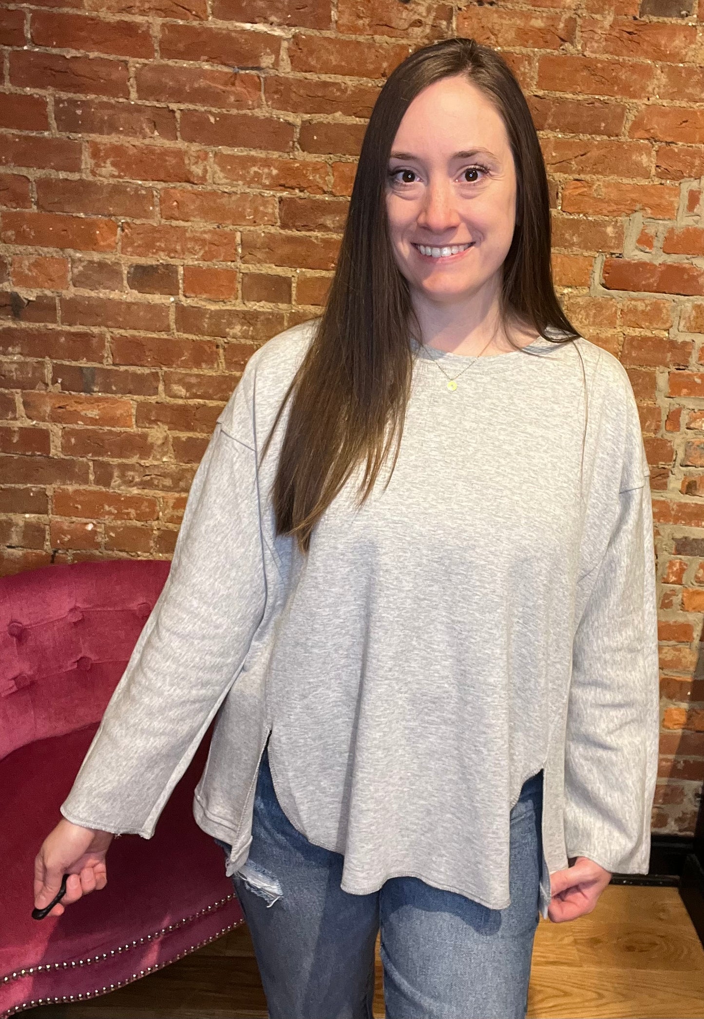 woman wearing a long sleeve cream-colored pull over sweater with denim jeans and boots