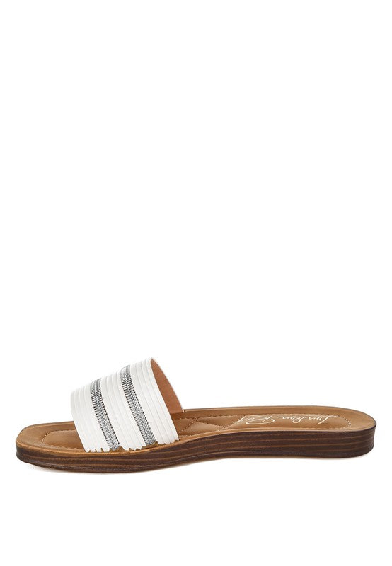 White sandal with a brown sole on a white background