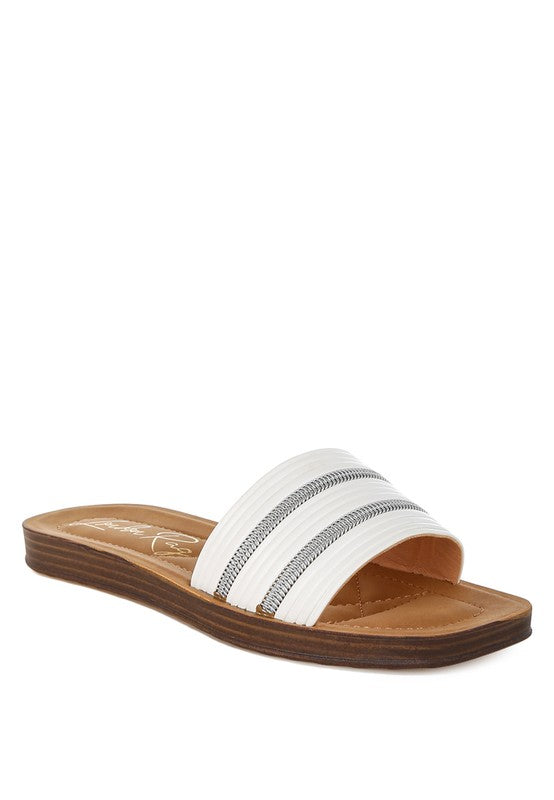 White sandal with brown sole on a white background
