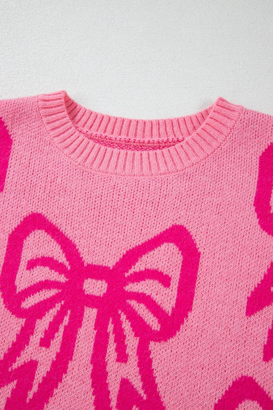 Pink sweater with large pink bows on a light gray background