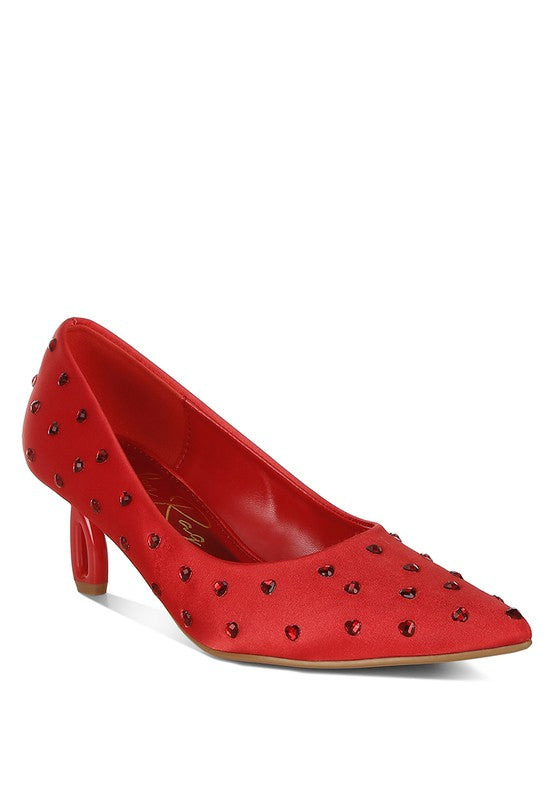 Red high-heeled shoe with studded details on a white background