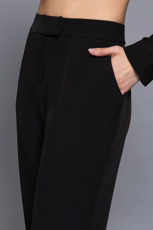 Black pants worn by a person on a gray background