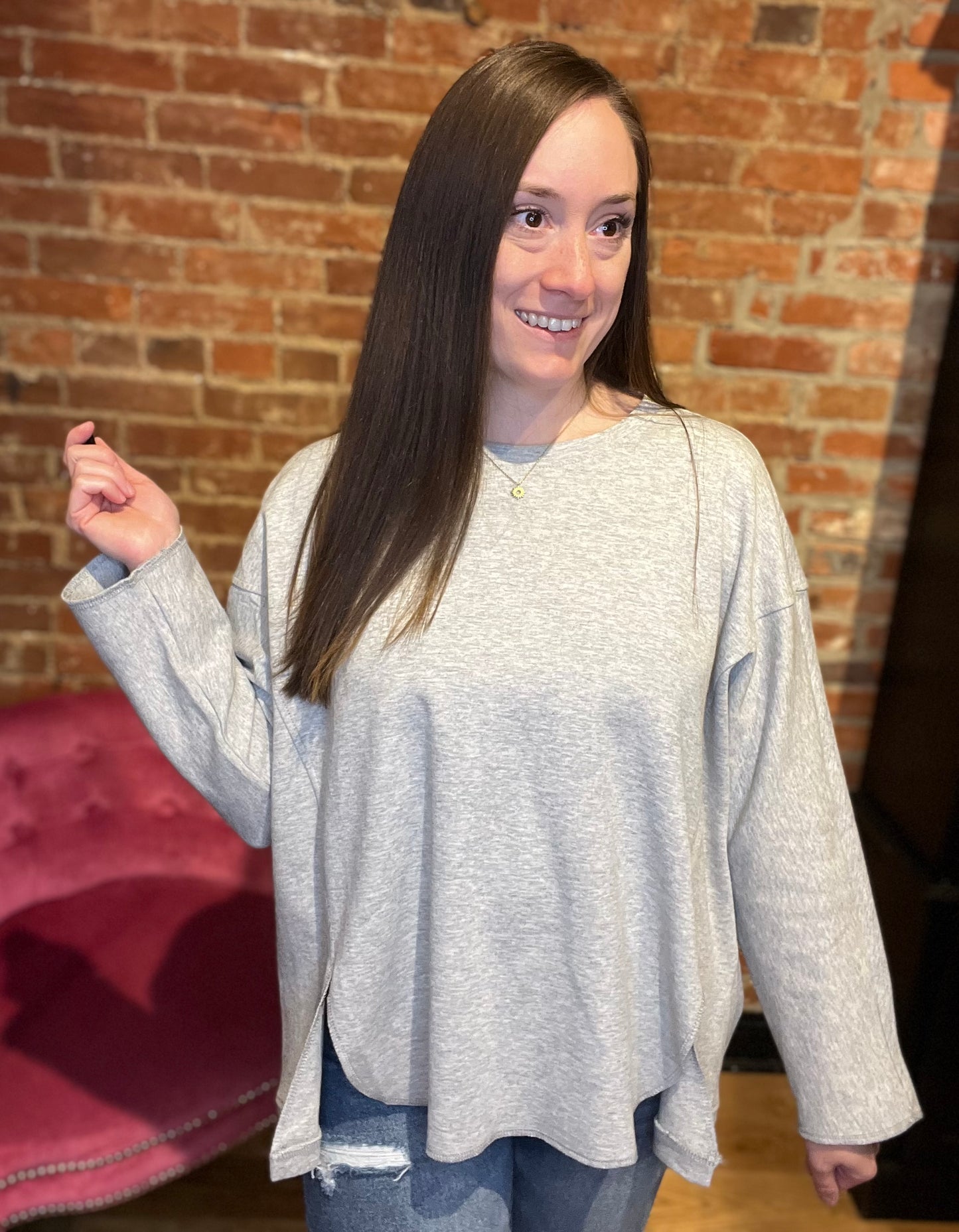 woman wearing a long sleeve grey-colored pull over sweater with denim jeans and boots