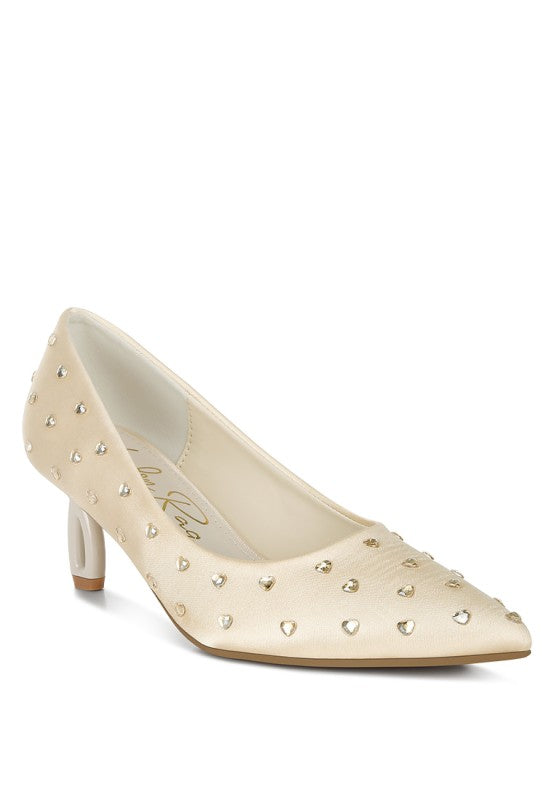 Beige high-heeled shoe with decorative studs on a white background