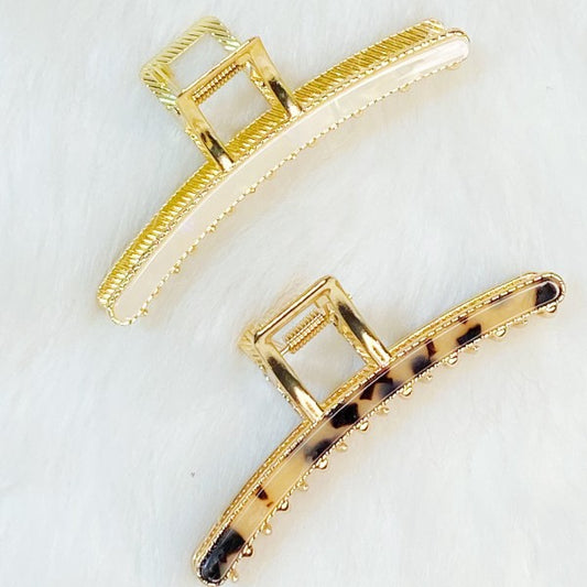 Two gold hair clips on a white background