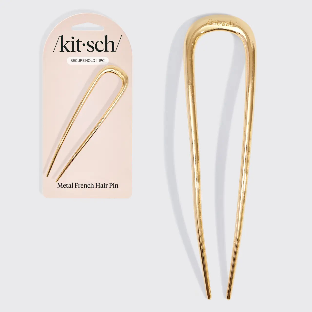 Gold metal French hair pin with packaging labeled 'kitsch' on a white background