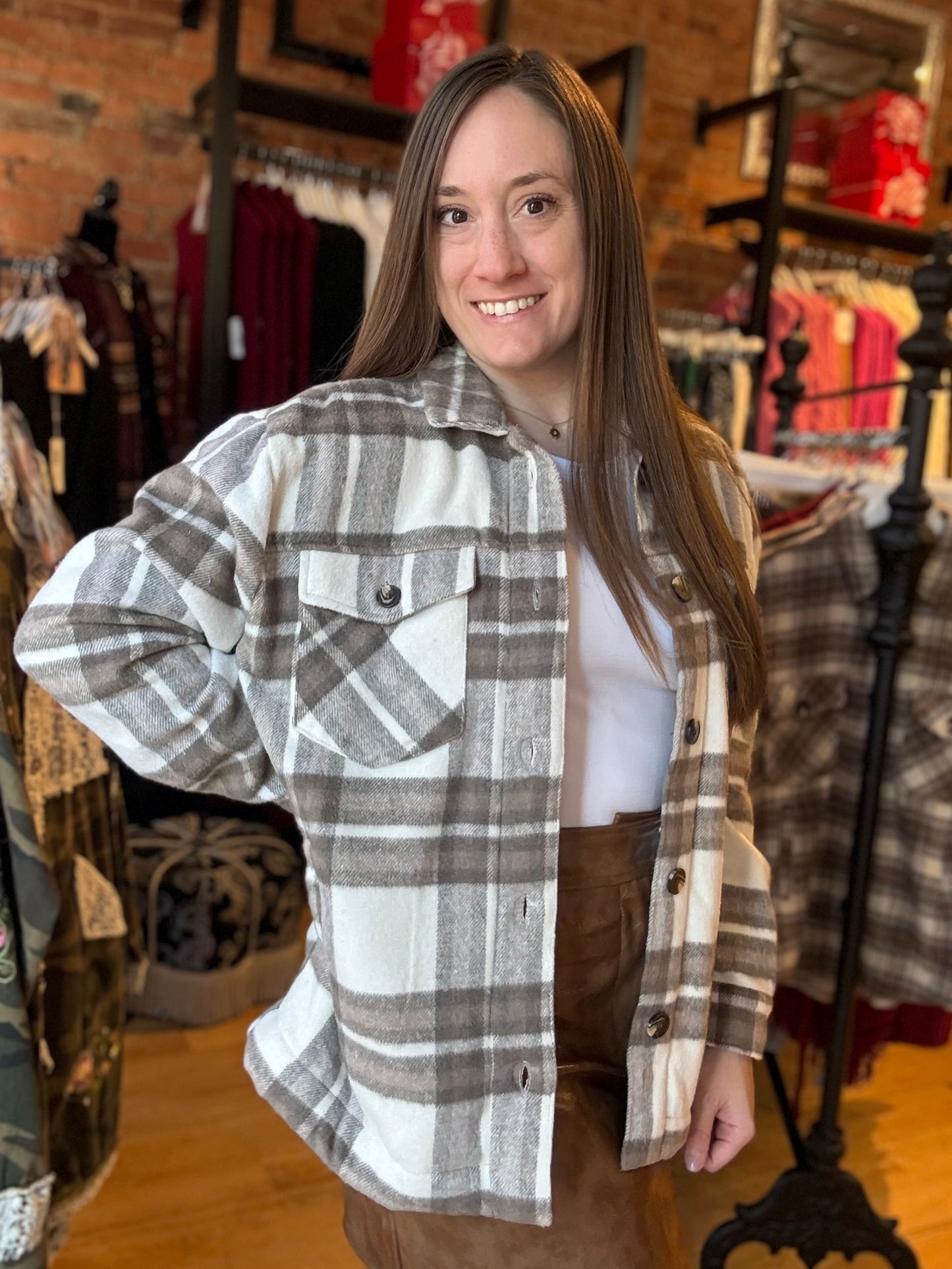 Woman wearing a plaid shirt in a clothing store setting