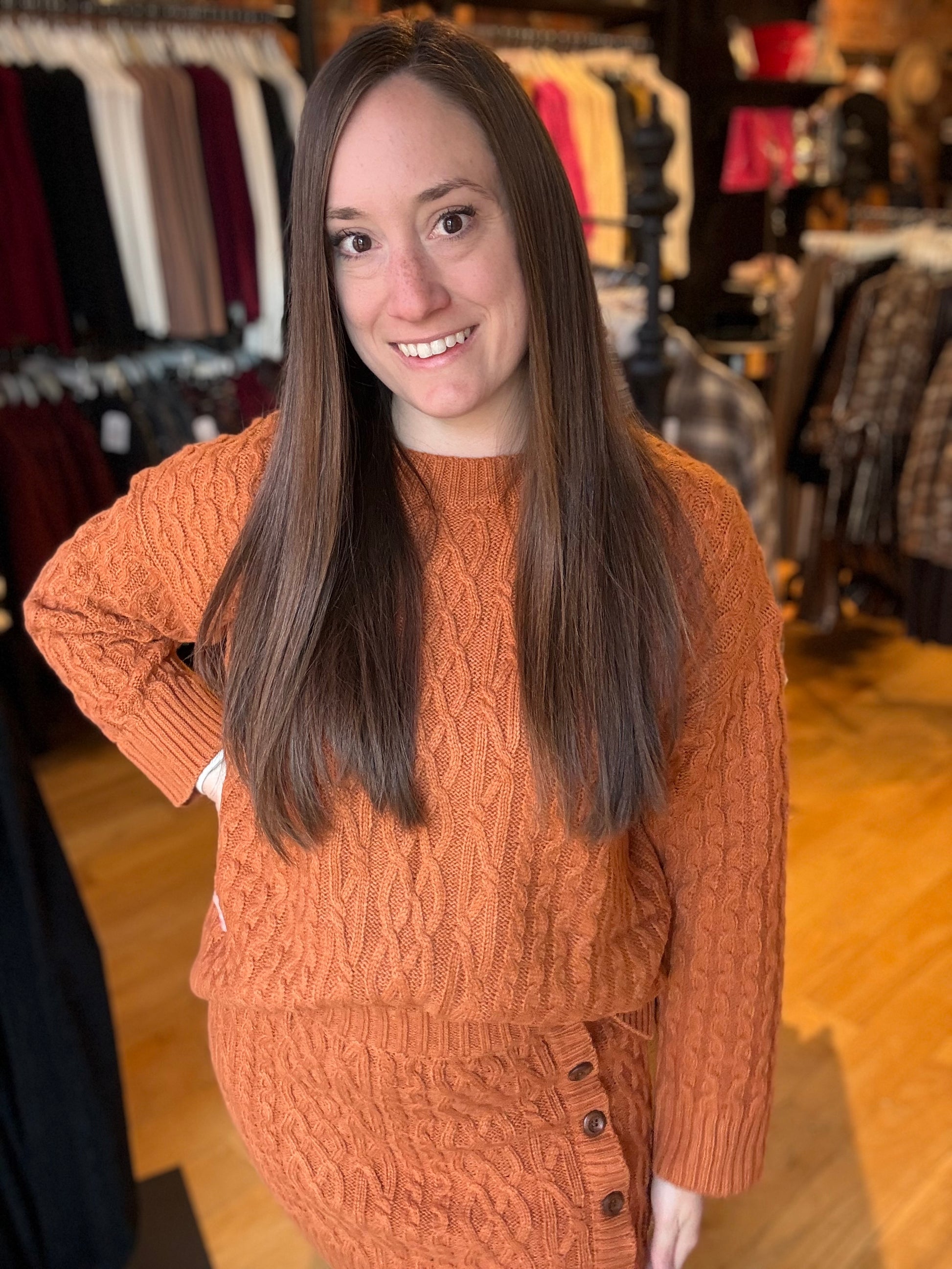 Woman wearing an orange sweater in a clothing store