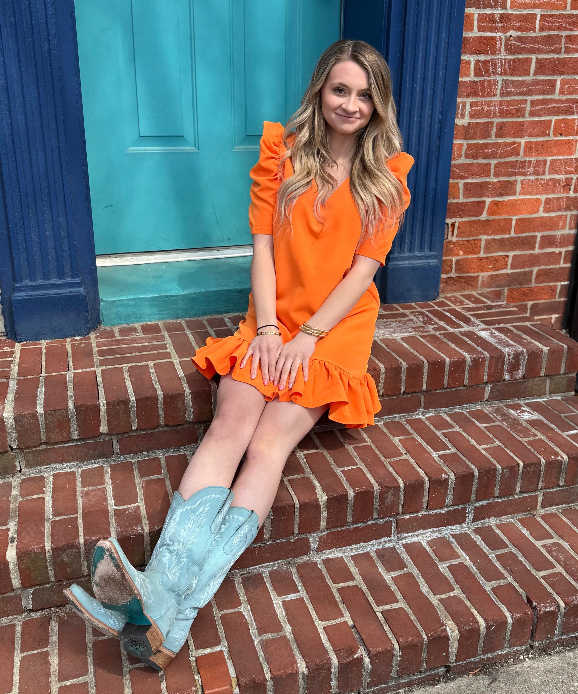 Orange mini dress with puff sleeves, straight-cut neckline, and darted bodice