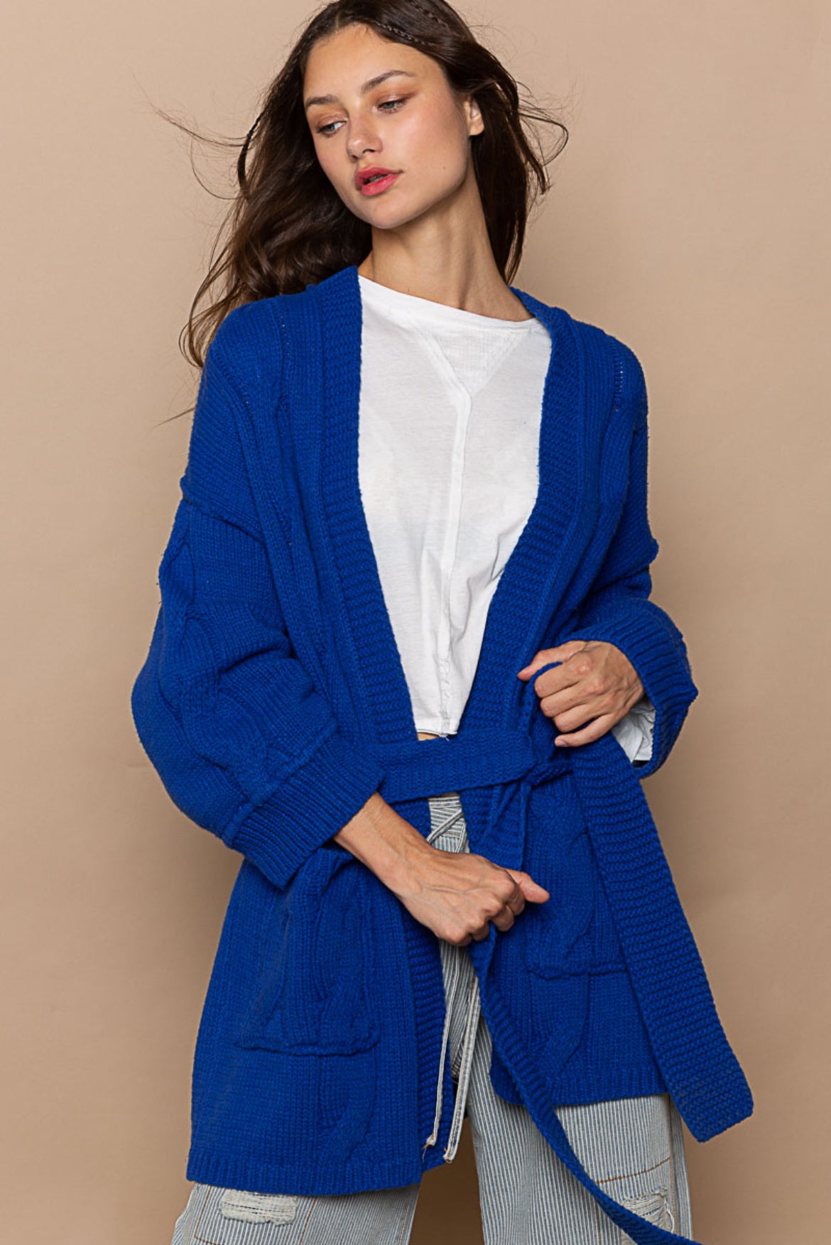 Blue cardigan sweater, relaxed fit, dropped shoulders, long sleeves, open front with waist tie wrap, pockets, kimono silhouette.