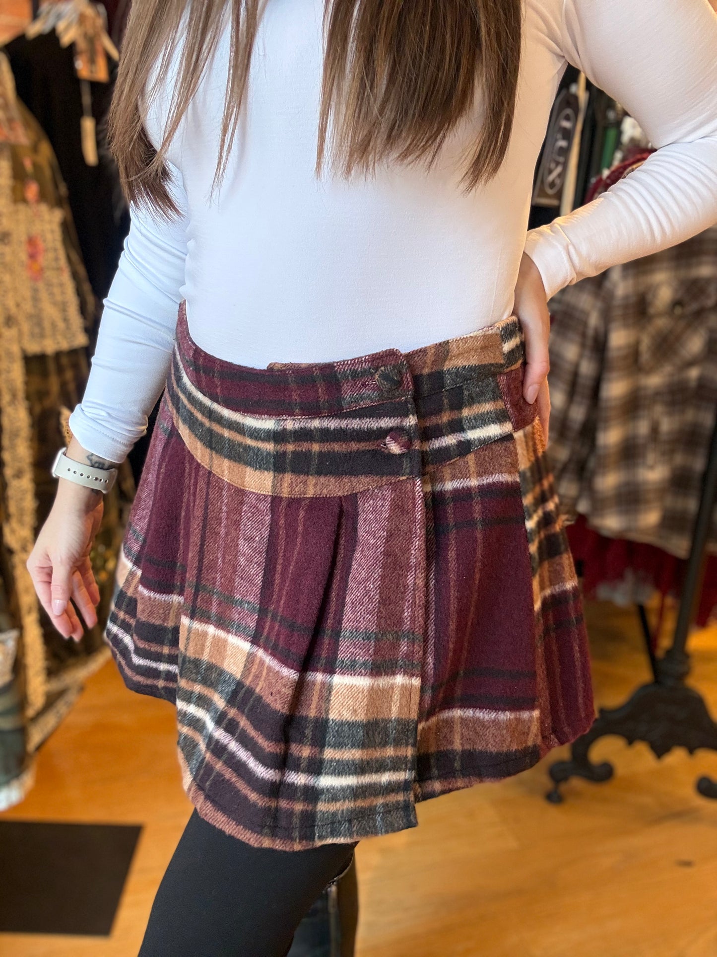 Person wearing a plaid skirt in a clothing store setting