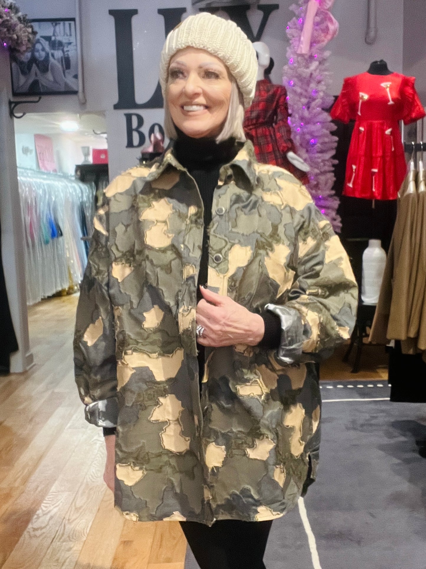 Woman wearing a camouflage jacket in a clothing store