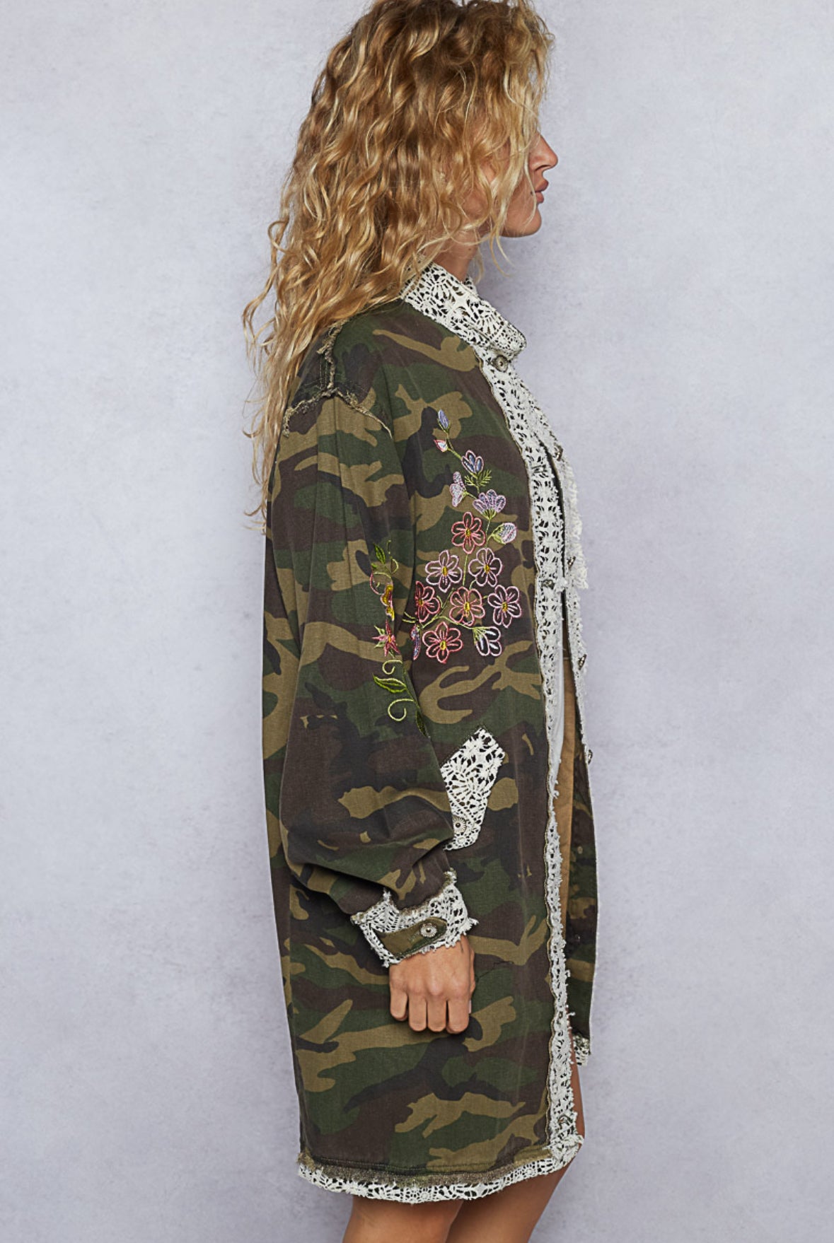 Camouflage dress with floral embroidery and lace details on a plain background