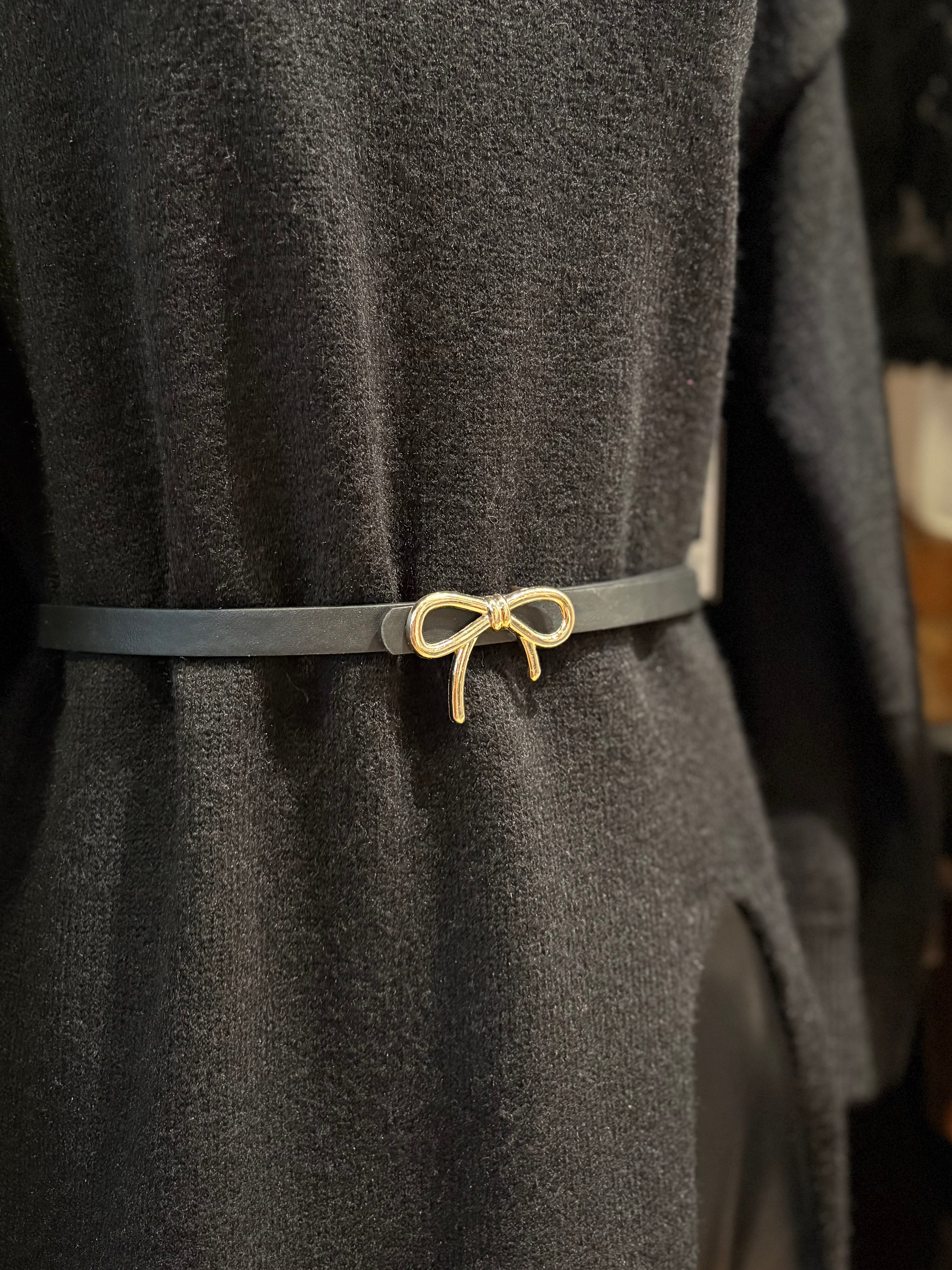 Gray coat with a gold bow-shaped belt buckle