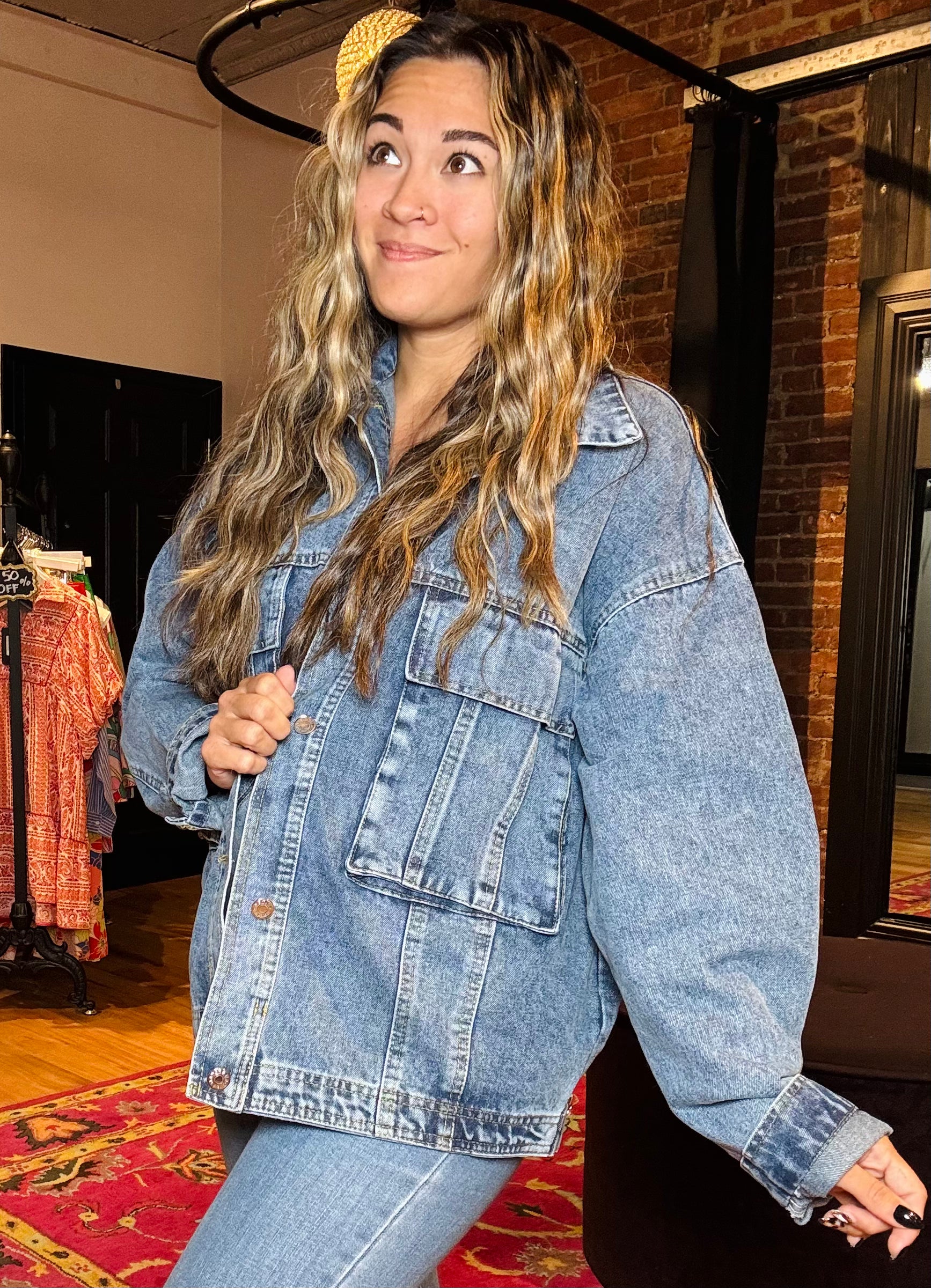 Woman wearing a denim jacket in a store setting