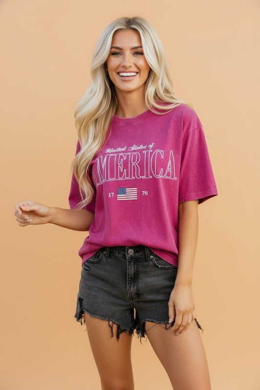 Woman wearing a pink t-shirt with 'Made in America' text on a beige background