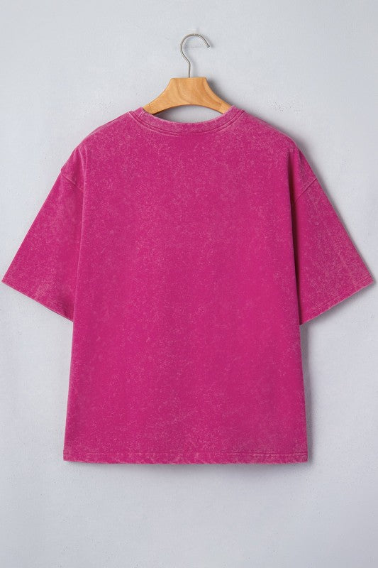 Pink t-shirt on a wooden hanger against a light gray background