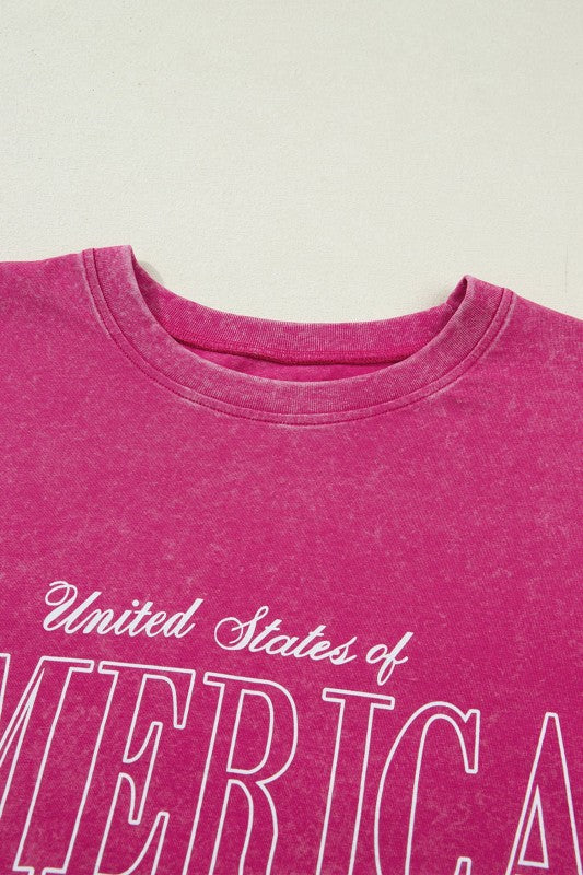 Pink t-shirt with 'United States of America' text on a light background