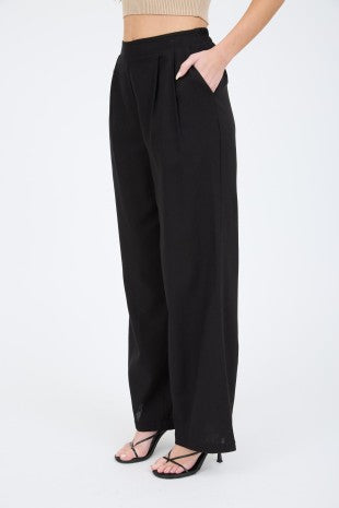 Person wearing black wide-leg pants on a white background