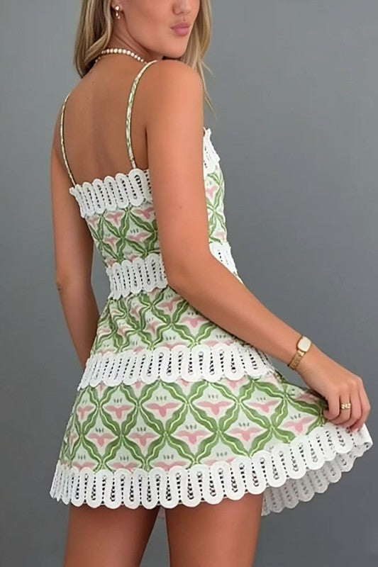 Woman wearing a patterned dress with lace details on a gray background