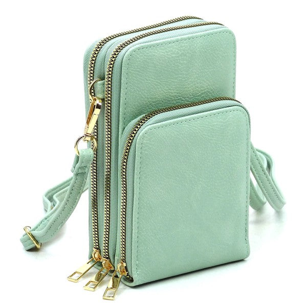 Mint green crossbody bag with gold zippers on a white background