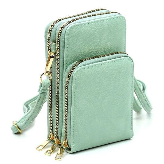 Mint green crossbody bag with gold zippers on a white background