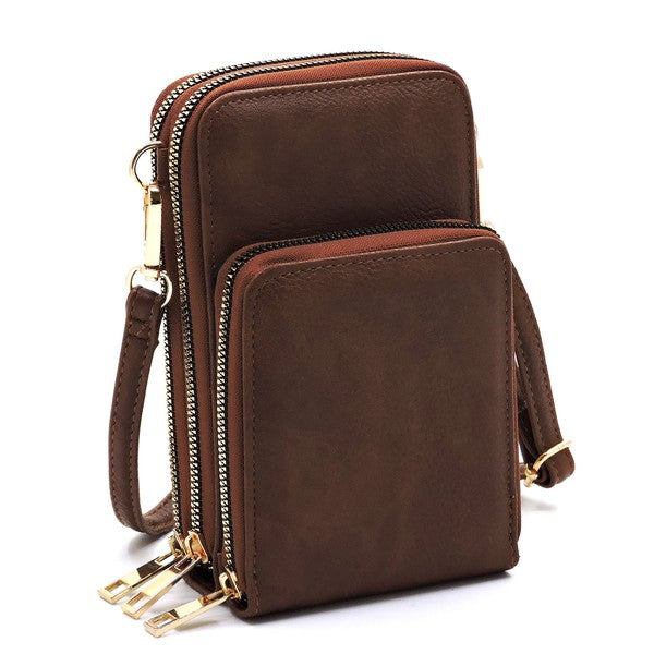 Brown leather crossbody bag with gold zippers on a white background