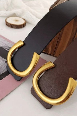 Black belt with gold buckle on a white surface