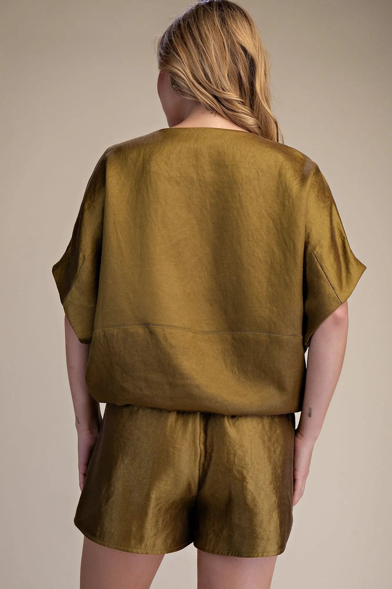 Person wearing a green outfit with a plain background