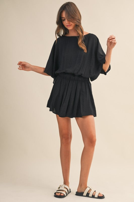 Woman wearing a black outfit on a beige background